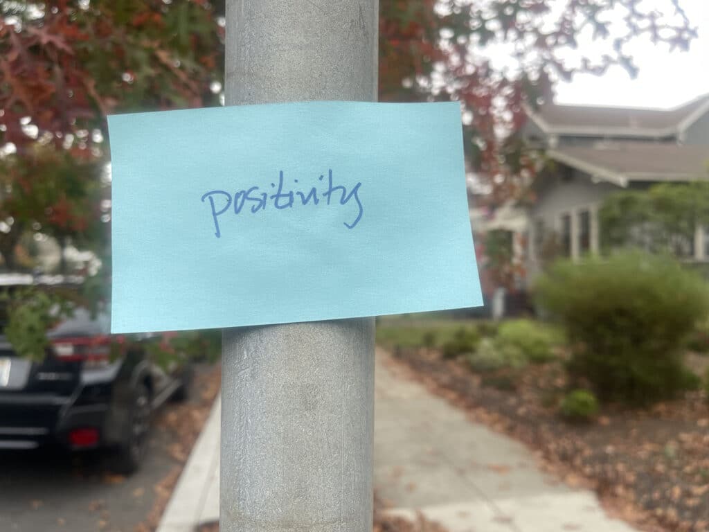 Alameda Post - a handwritten note on pole that says "positivity"