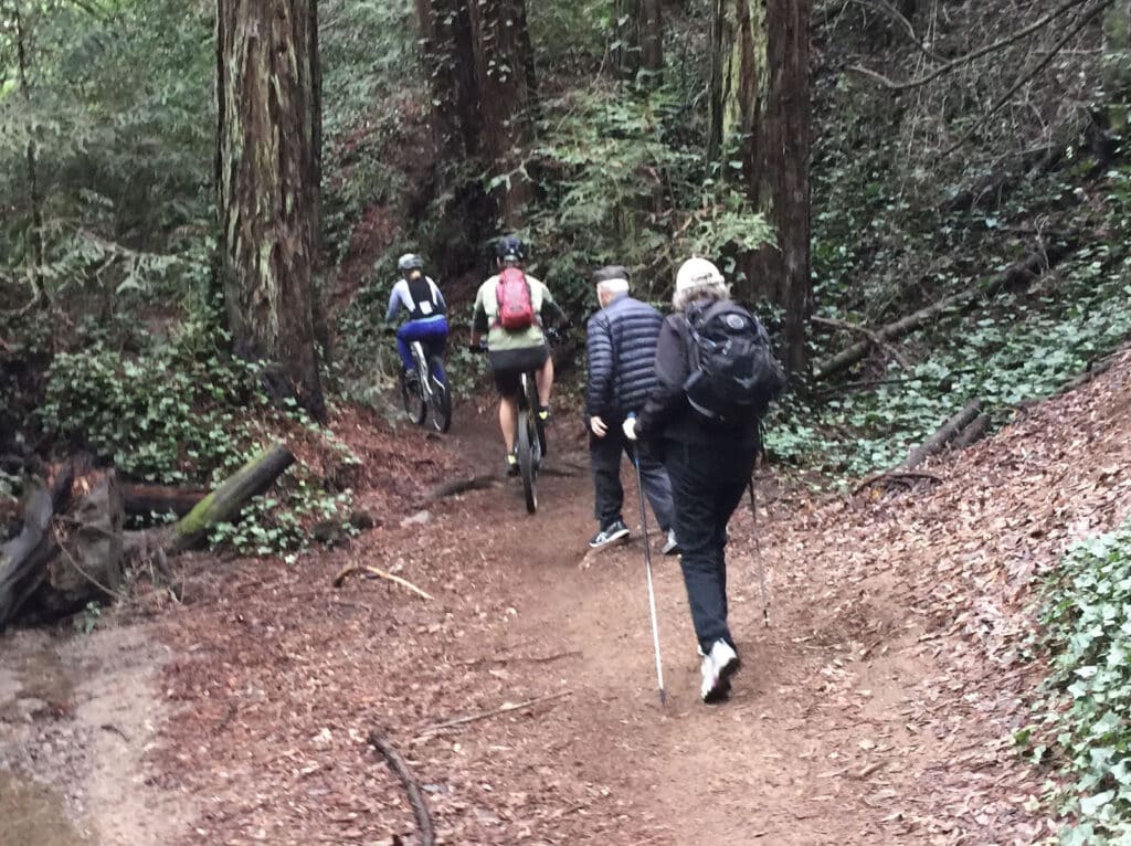 Alameda Post - two hikers are passed by two bikers on a narrow trail