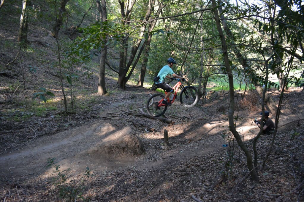 Alameda Post - a teen rides their bike in the woods