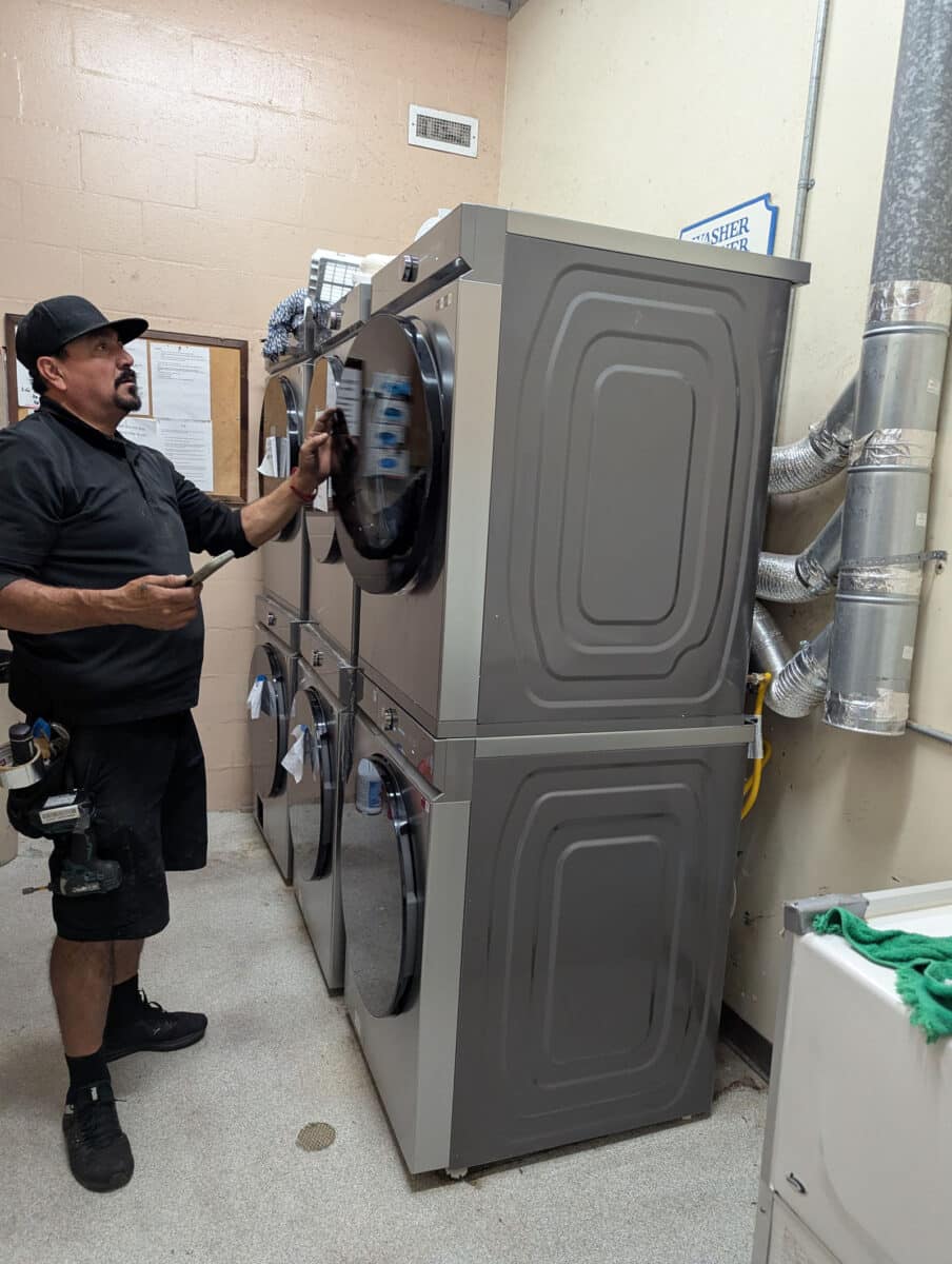 Alameda Post - a worker works on washers and dryers 