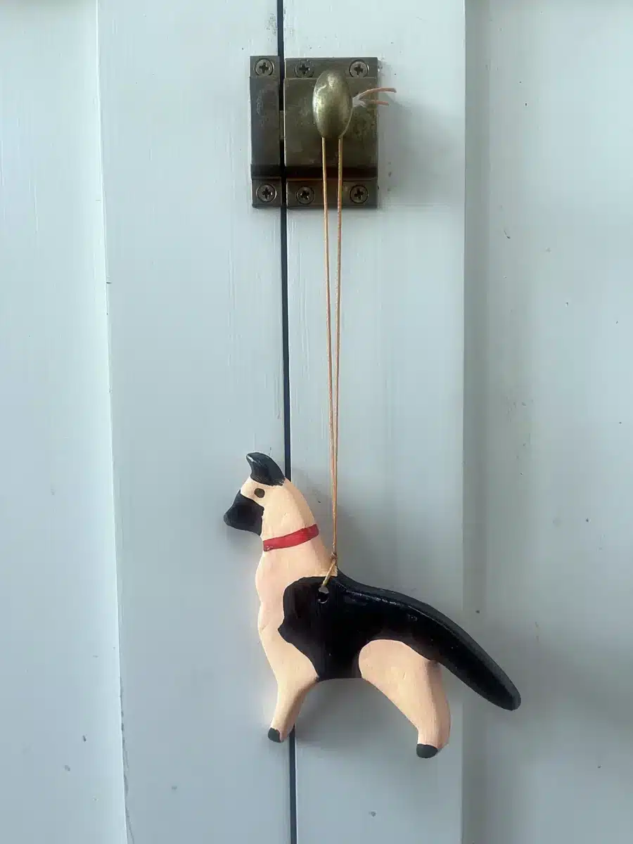 Alameda Post - a German shepherd ornament hanging from a kitchen cabinet latch