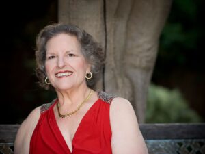 Alameda Post - Carol Dean smiles for the camera in a fancy red outfit