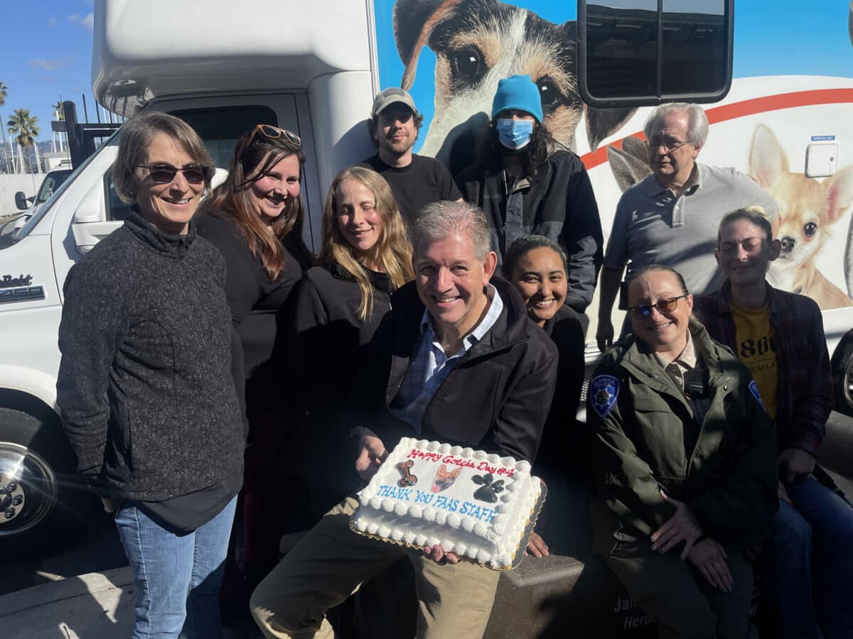 Alameda Post - the staff of FAAS gathers around a cake and smiles