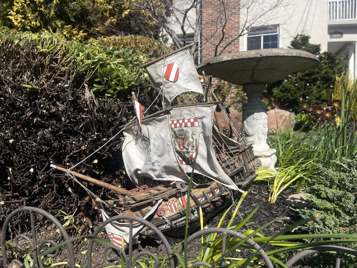 Alameda Post - a wood and cloth replica toy boat sitting in front of a bird bath