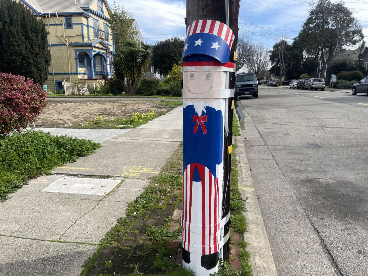 Alameda Post - a cheerful red, white, and blue Uncle Sam painted on the metal of a utility pole