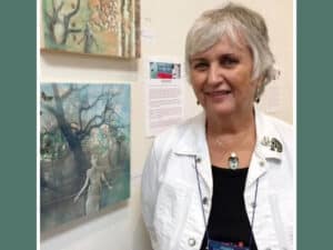 Alameda Post - Bonnie Randall Boller stands next to paintings on a gallery wall
