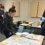 Alameda Post - APD officers organize and investigate a large pile of papers on a table