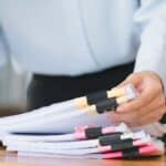 Alameda Post - a photo of somebody at a business sorting through a stack of papers