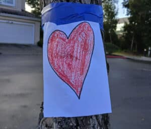 Alameda Post - a piece of printer paper with a heart drawn on it taped to a tree