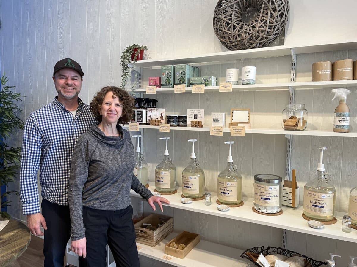 Alameda Post - the husband and wife team behind Replenish Marketplace stands with shelves of products, including large pump containers.