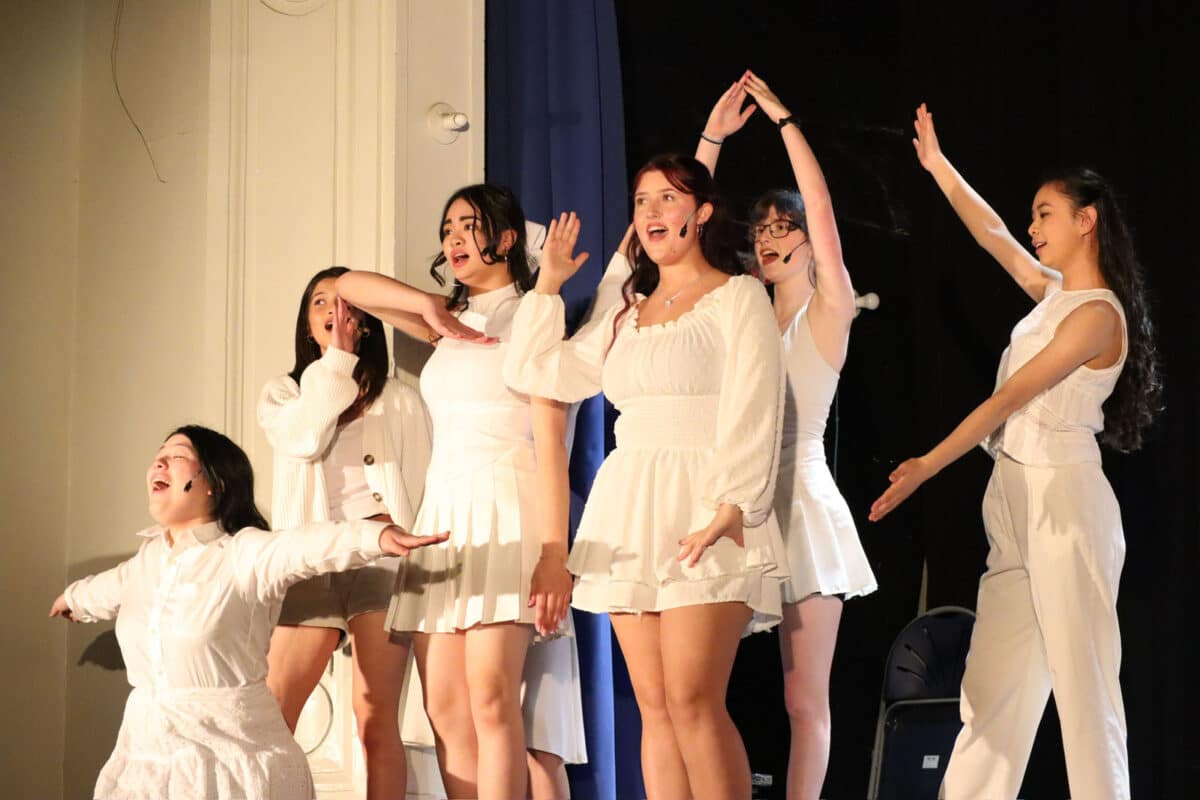 Alameda Post -a group of actresses wearing short white dresses sings