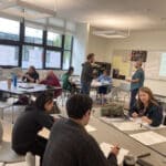 Alameda Post - an AUSD classroom with teachers or other adults sitting and working at large group desks