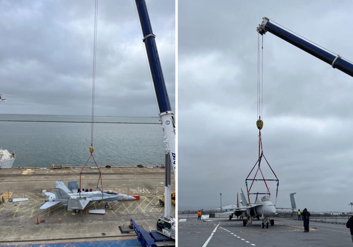 Alameda Post - The F/A-18C Hornet is lifted onto the flight deck of the USS Hornet using a large crane