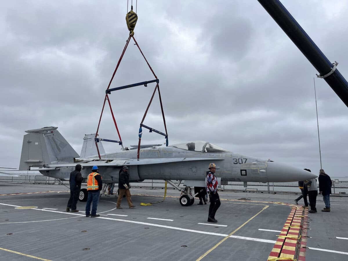 Alameda Post - people walk around a plane on the USS Hornet