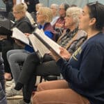 Alameda Post - Alameda Sings singers hold music and look towards the director in rehearsal for "Let' Be the Music"