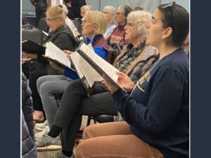Alameda Post - Alameda Sings singers hold music and look towards the director in rehearsal for "Let' Be the Music"