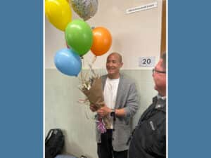 Alameda Post - teacher of the year Michael Wong holds a bunch of balloons