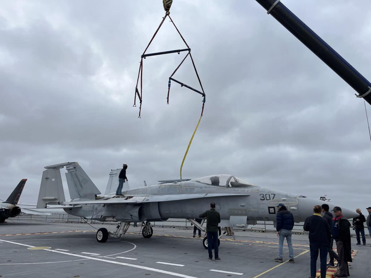 Alameda Post - straps release from a small plane atop the USS Hornet aircraft carrier