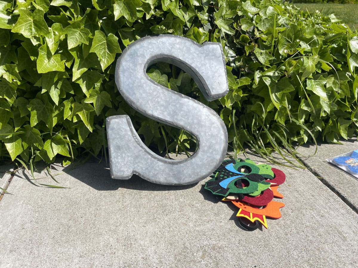 Alameda Post - a large metal S and some whimsical masks on the sidewalk