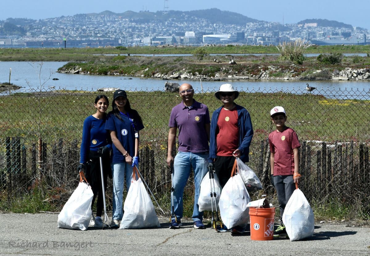 Alameda Post - five volunteers hold trash bags and smile