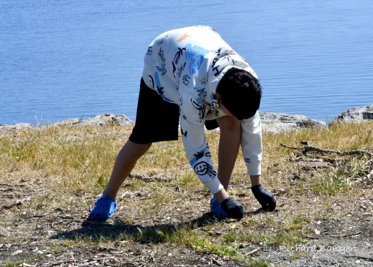 Alameda Post - a volunteer bends down to pickup trash
