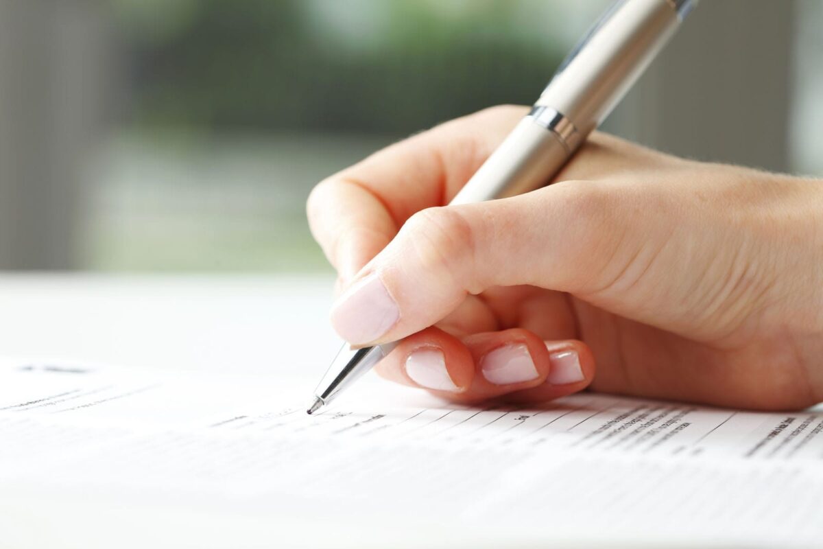 Alameda Post - a woman's hand holds a pen and fills out a form