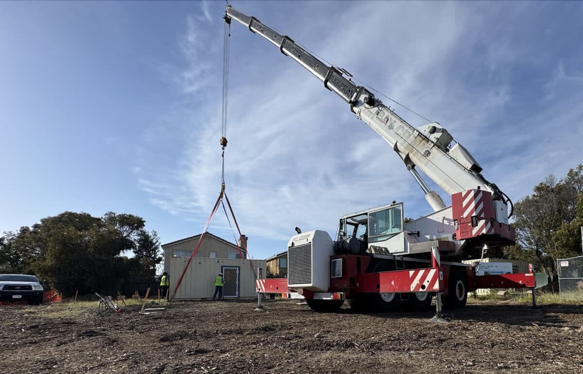 Alameda Post - heavy machinery lowers a container onto a construction site