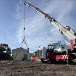 Alameda Post - heavy machinery lowers a container onto a construction site