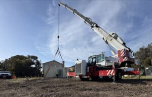 Alameda Post - heavy machinery lowers a container onto a construction site