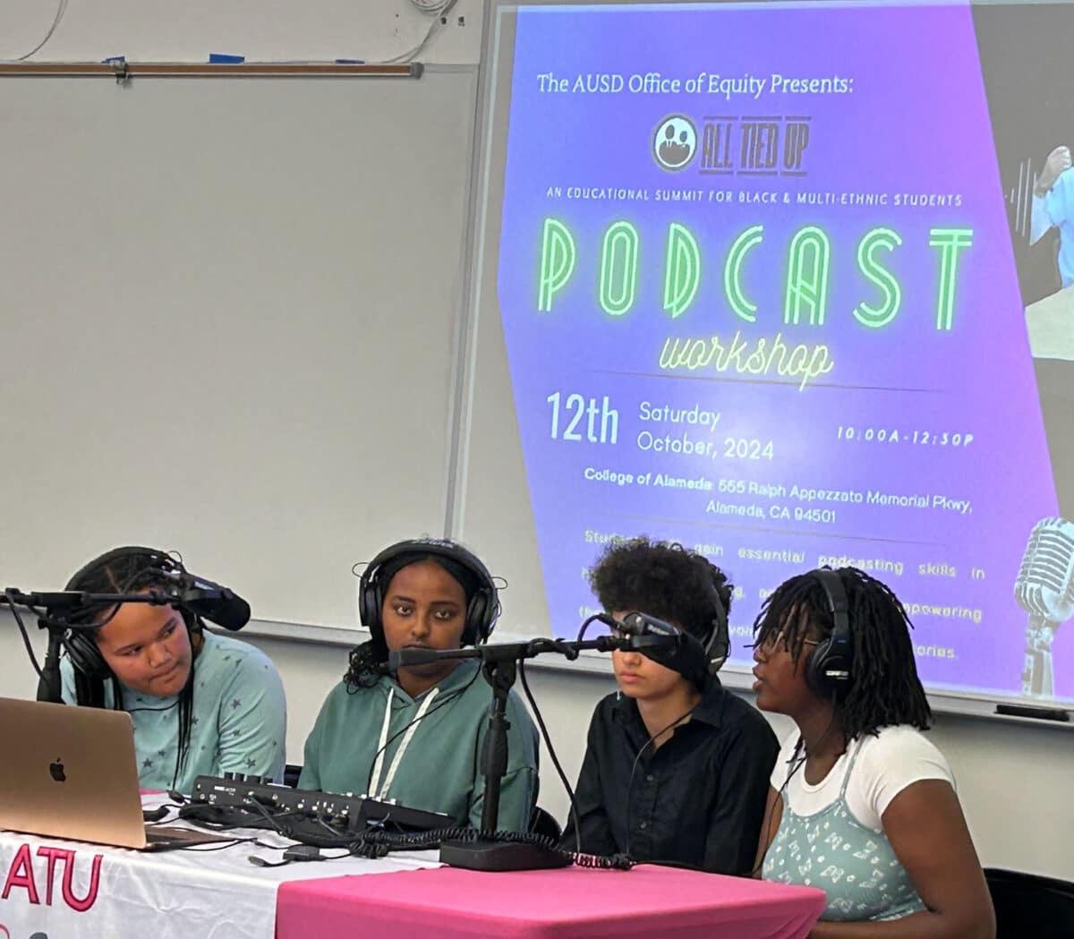 Alameda Post - four students sit at a podcast station and speak into microphones