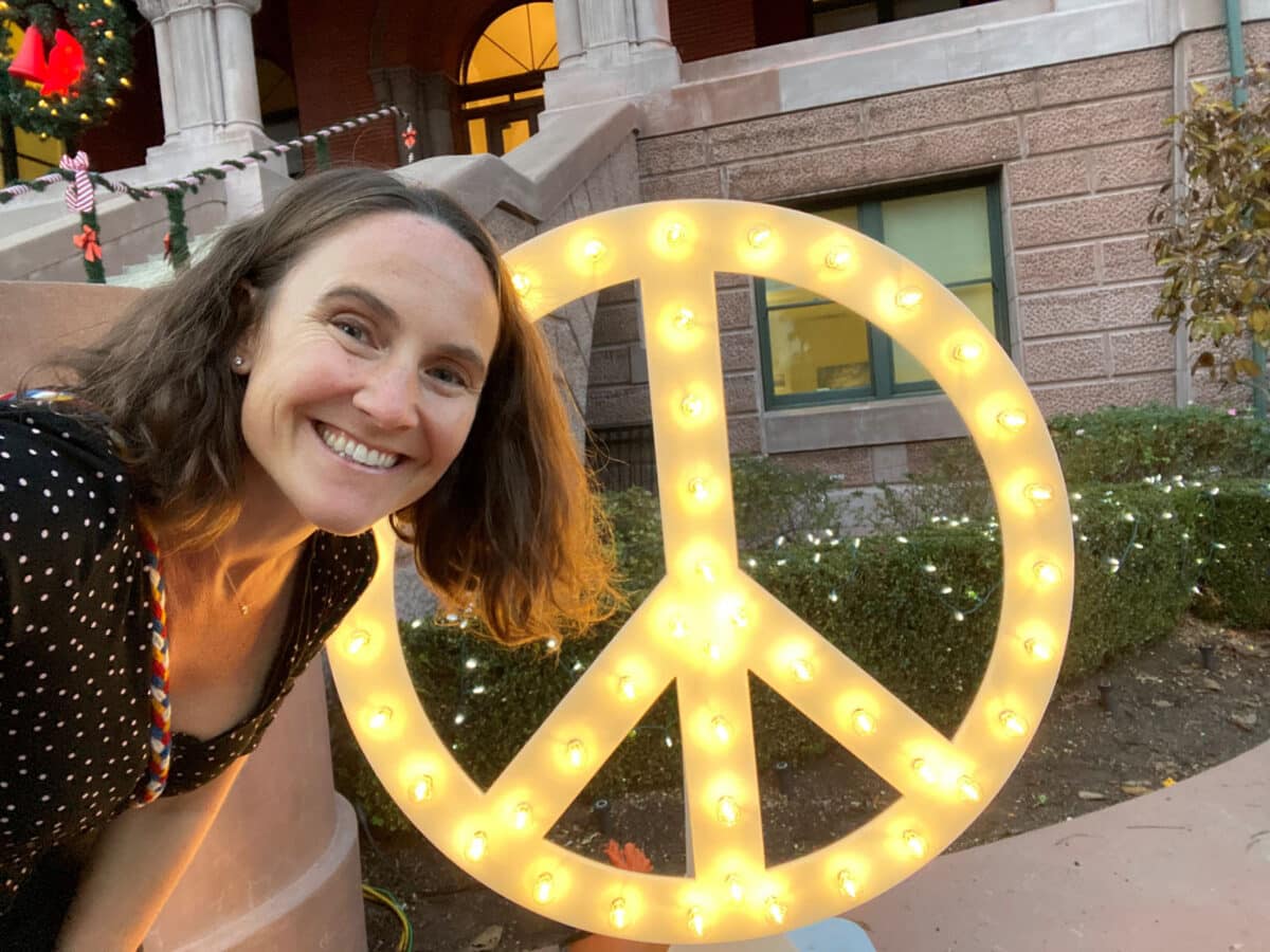 Alameda Post - Sarah Henry takes a selfie with a large lit peace sign