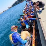 Alameda Post - a team of Alameda DragonFlyers in their boat turn to smile at the camera