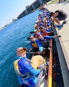 Alameda Post - a team of Alameda DragonFlyers in their boat turn to smile at the camera