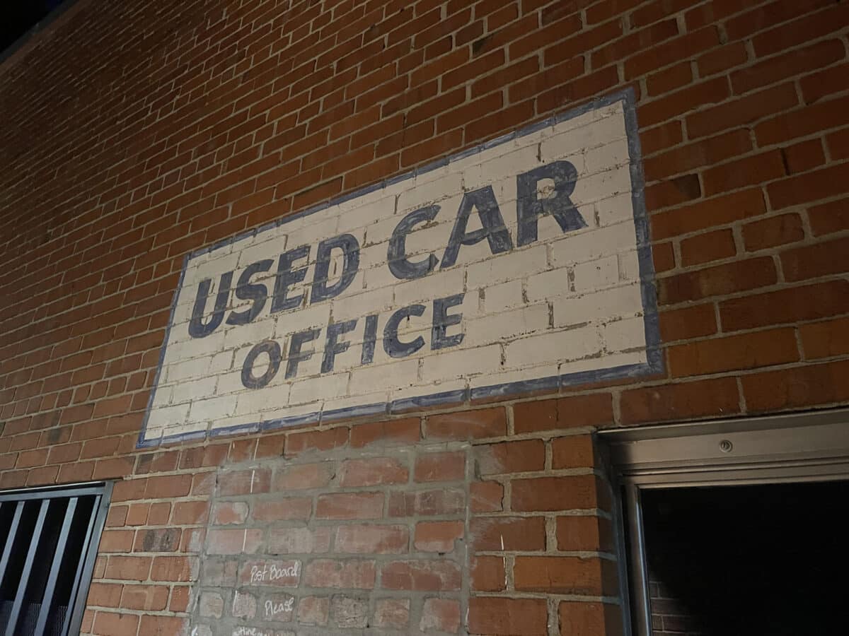 Alameda Post - a painted sign on a brick wall that says Used Car Office