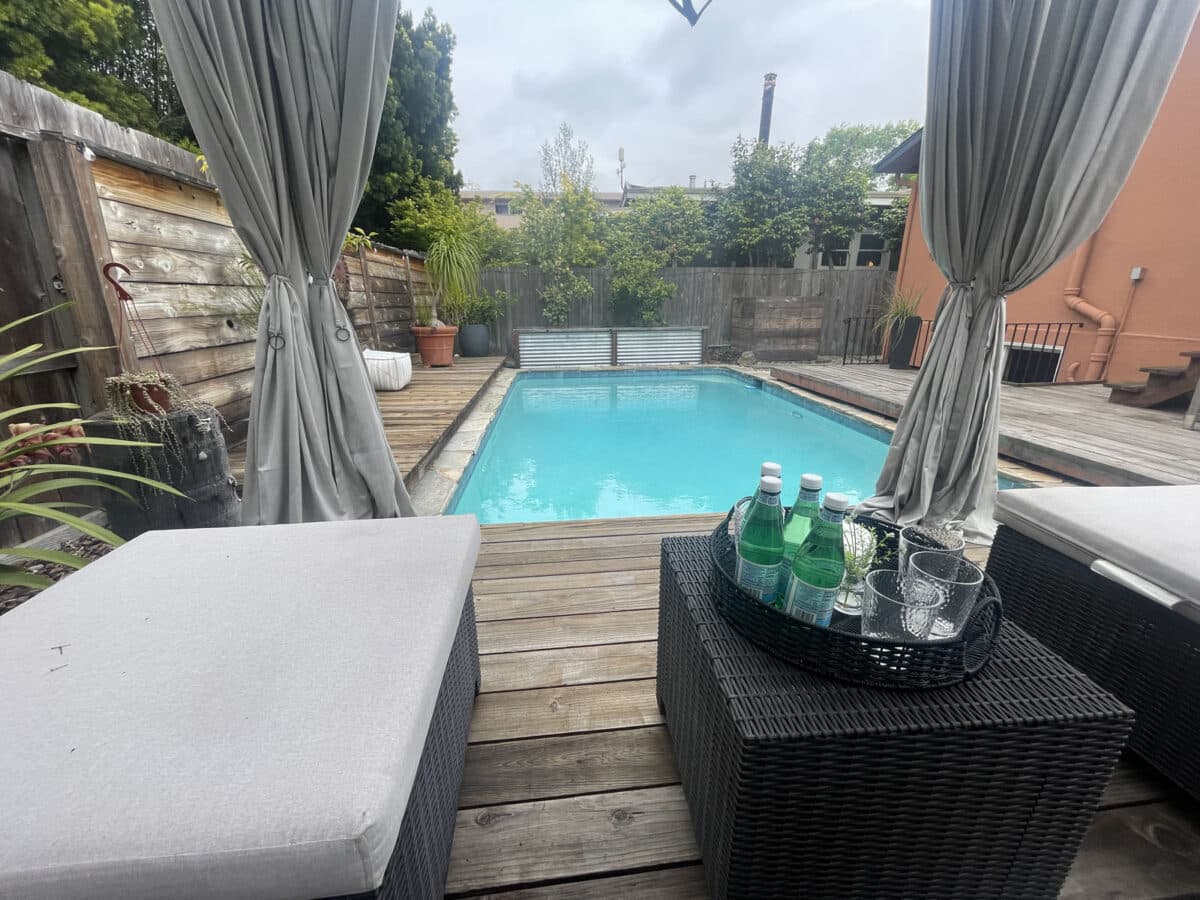 Alameda Post - a lounge and cabana area that overlooks a backyard pool 