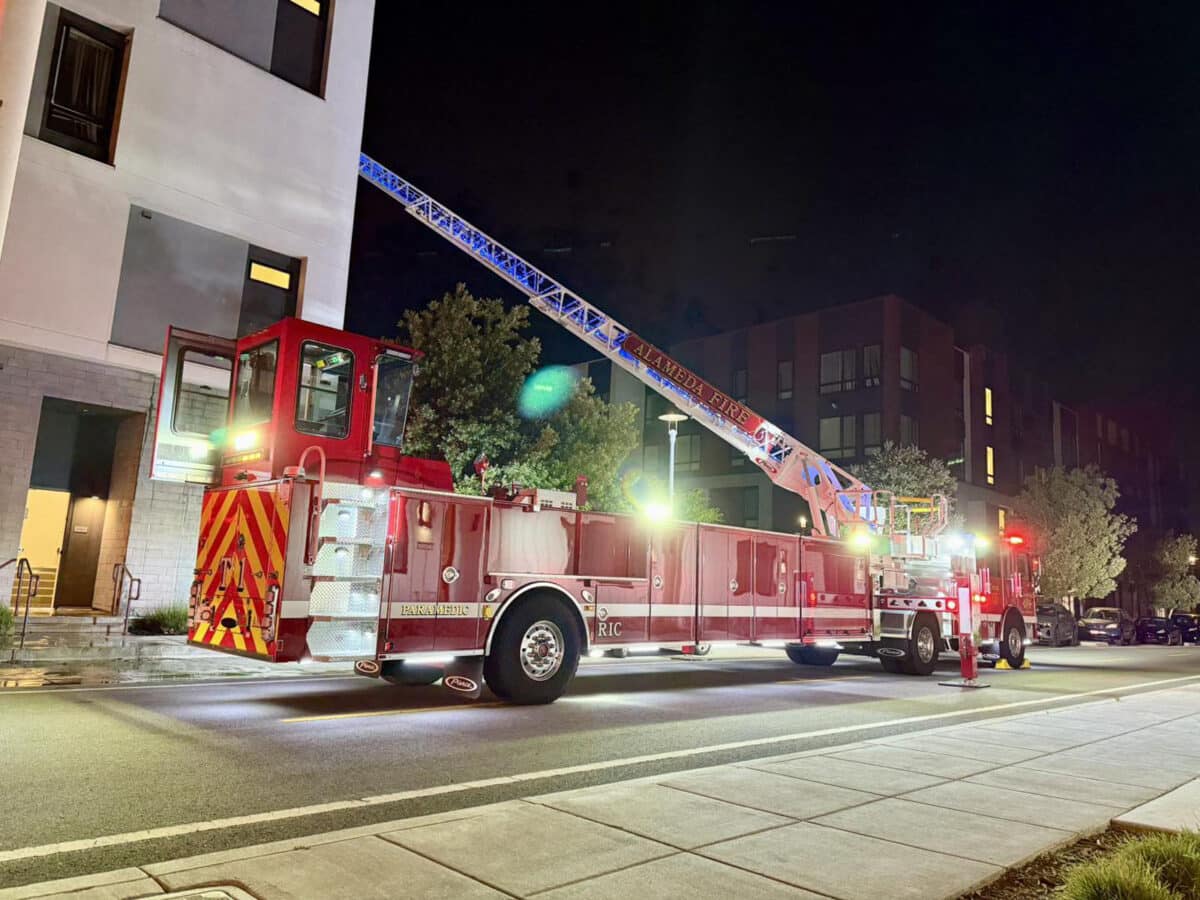 Alameda Post - an Alameda Fire Department truck sits next to a West Atlantic Avenue building with the ladder raised high and out of sight 