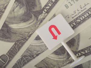 Alameda Post - a stack of currency with a u-turn sign laying on top of it