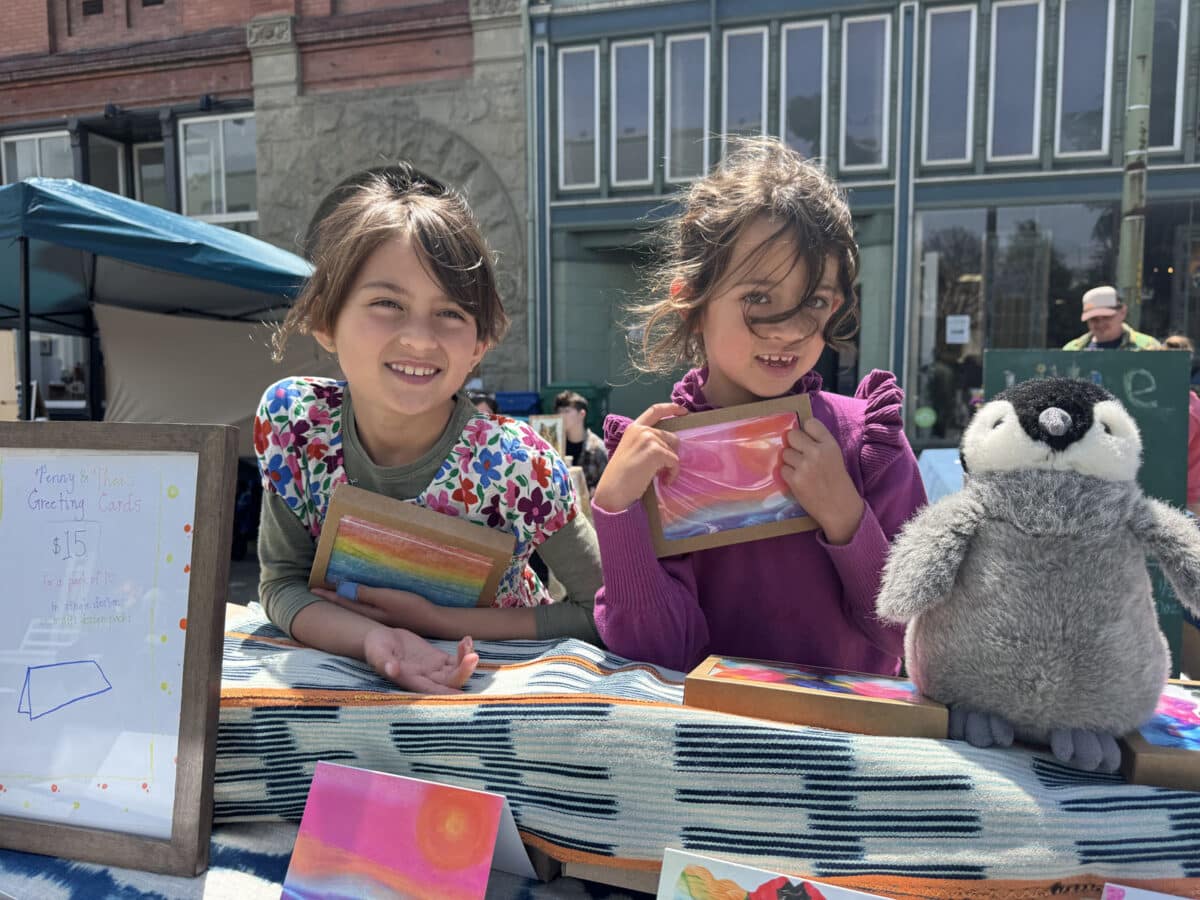 Alameda Post - two girls smile at their booth at the Children's Business Fair