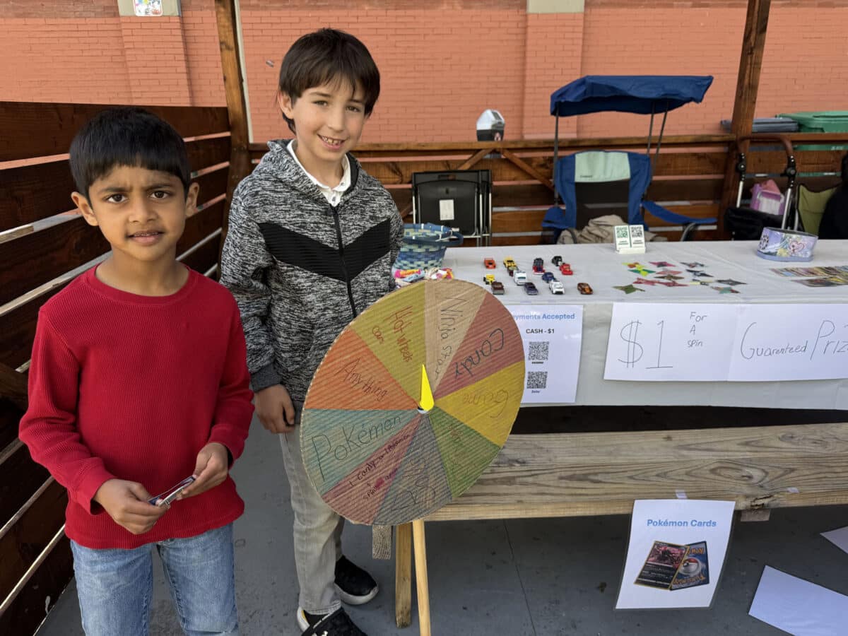 Alameda Post - two young boys stand next to a homemade prize wheel