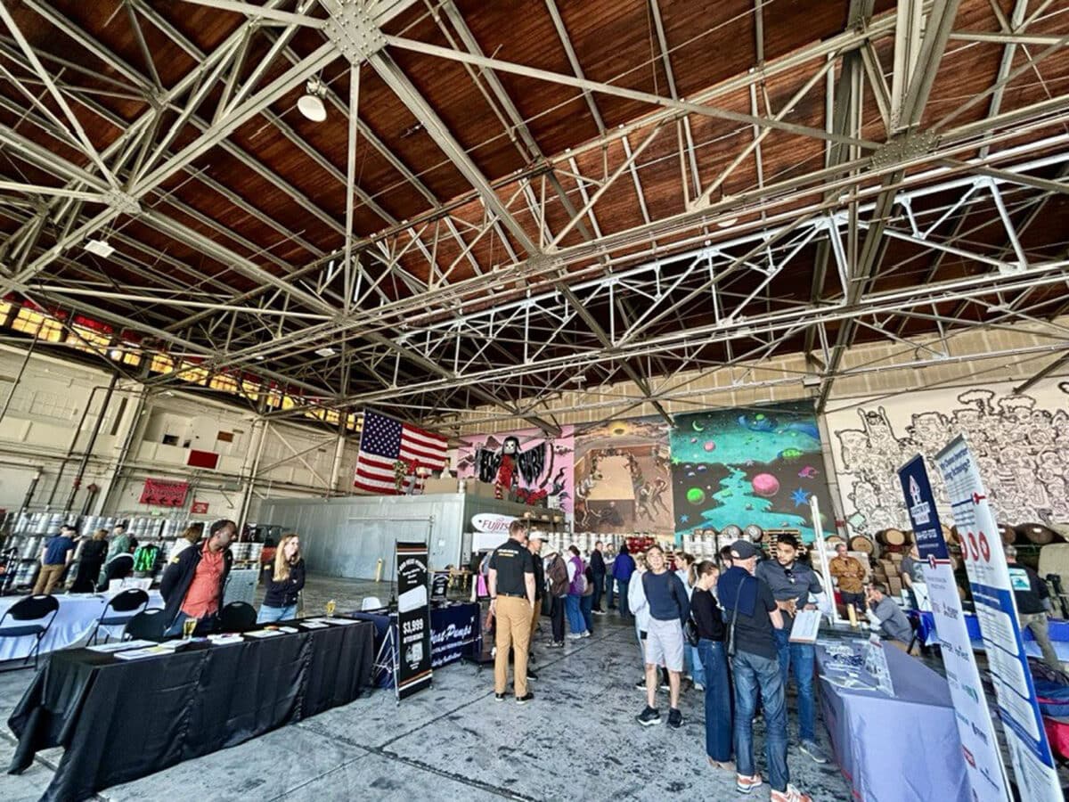Alameda Post - inside Faction Brewing, attendees of the Home Electrification Fair mill around and visit booths
