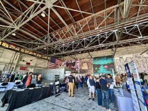 Alameda Post - inside Faction Brewing, attendees of the Home Electrification Fair mill around and visit booths
