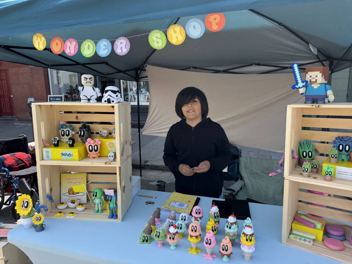 Alameda Post - a vendor at the Children's Business Fair stands at a booth with colorful and cute toys and decor
