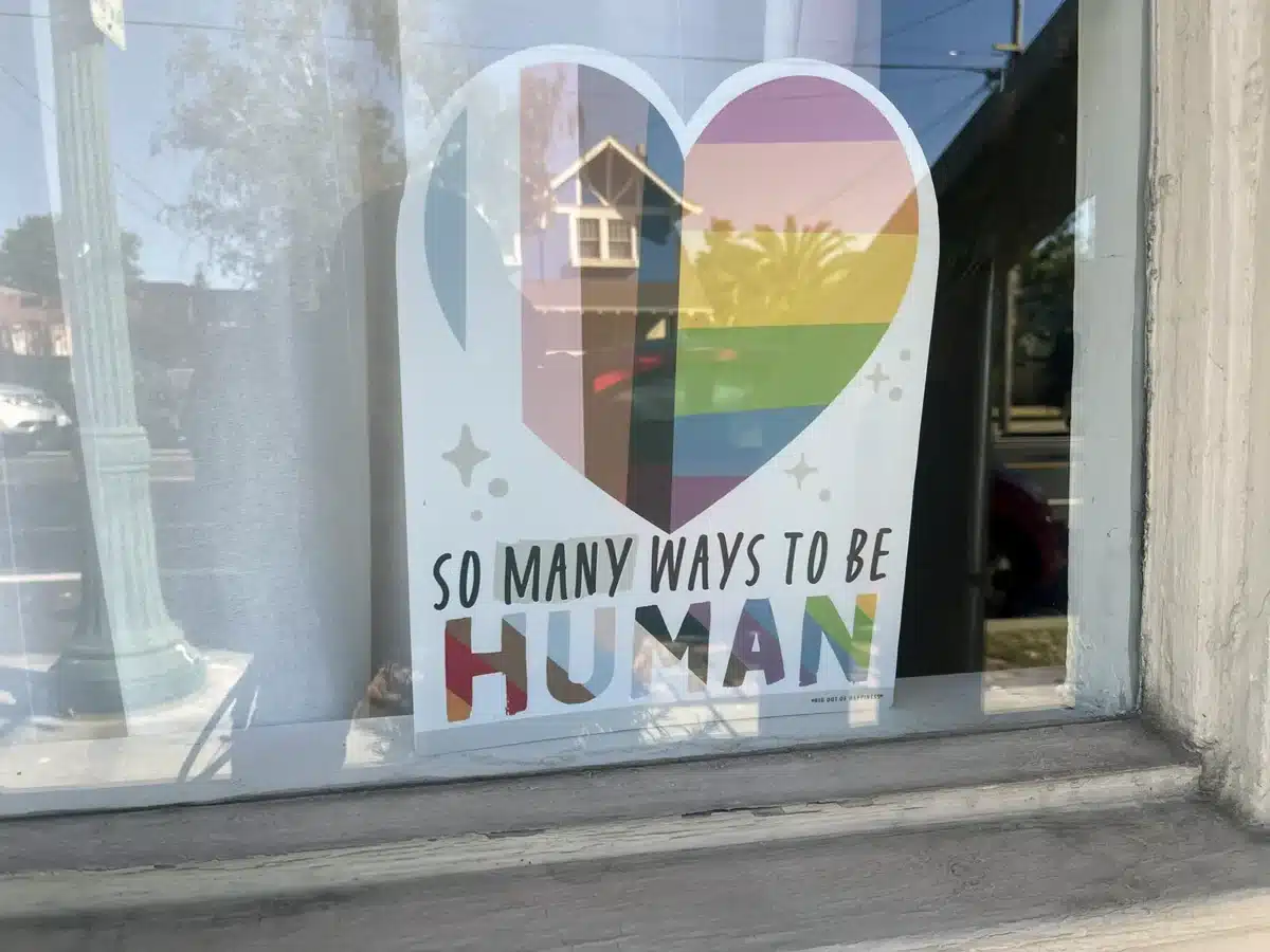 Alameda Post - Bear's-Eye View of Alameda for June 29, 2025. A sign in a window with a rainbow heart and the message "So many ways to be human"