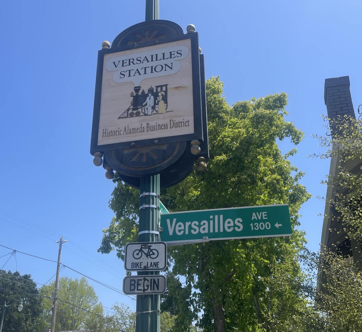 Alameda Post - a Versailles Ave street sign and an old fashioned looking sign that says Versailles Station Historic Alameda Business District