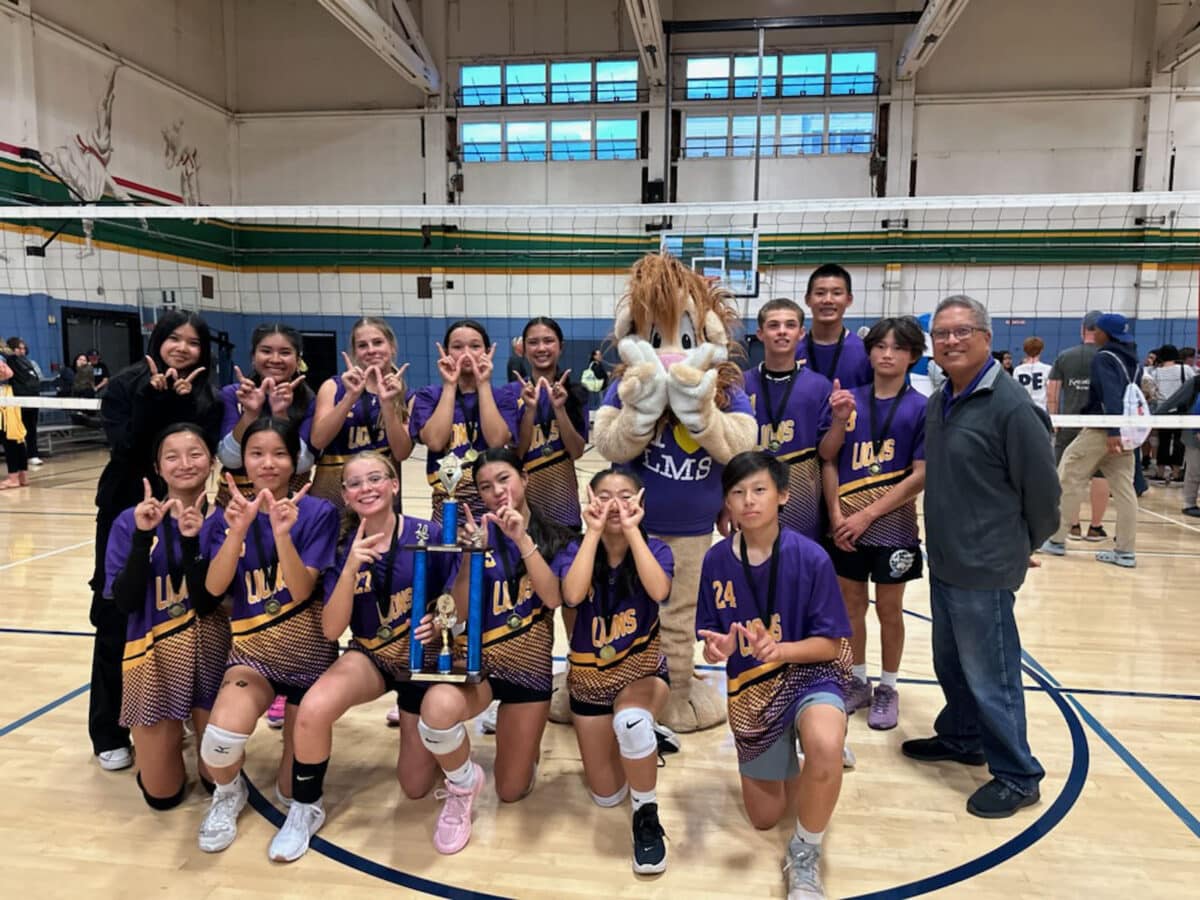 Alameda Post - a middle school volleyball team poses with a trophy