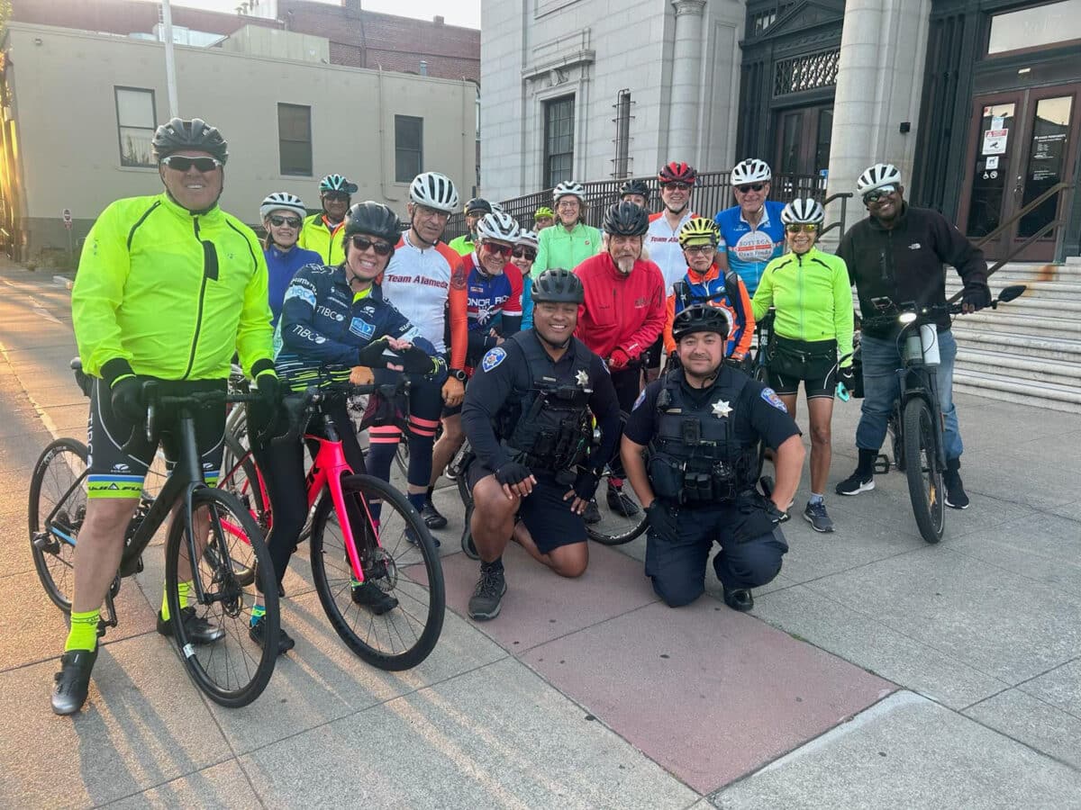Alameda Post - a group photo of a group of bicyclists, including APD officers, at the Ride of Silence