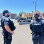 Alameda Post - two APD officers stand and look out over a parking lot