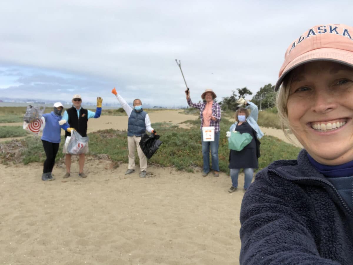 Alameda Post - a group of people cleaning up the beach smile for a selfie