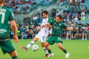 Alameda Post - an Oakland Roots and AV Alta FC player vie for the ball