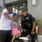 Alameda Post - a father and child take a selfie with an APD officer on a bike who is part of the new Business Patrol